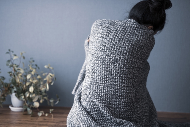 町内の集会所で一人きりに感じる女性の後ろ姿