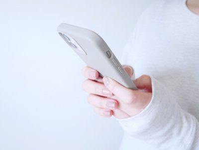 「スマートフォンを見つめる女性の横顔。返信を待ちながら、そっと胸の内に気持ちを抱えている様子